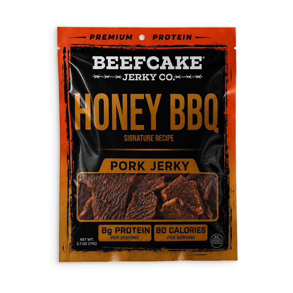A package of Beefcake Jerky Co. Honey BBQ Pork Jerky, featuring a black and orange design with a clear window showing the jerky pieces inside.
