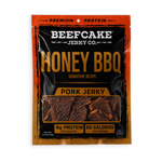 A package of Beefcake Jerky Co. Honey BBQ Pork Jerky, featuring a black and orange design with a clear window showing the jerky pieces inside.