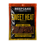 A package of Beefcake Jerky Co. Sweet Heat Pork Jerky, featuring a black and orange bag with yellow text and a clear window showing the jerky slices inside.