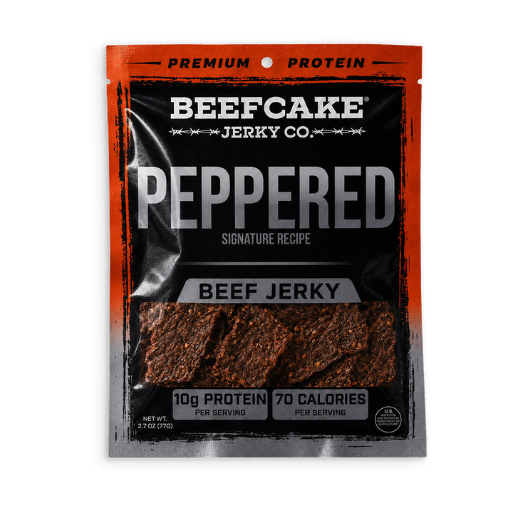 A package of Beefcake Jerky Co. Peppered Beef Jerky, featuring a black and orange resealable pouch with a clear window showing the textured, reddish-brown jerky pieces inside.